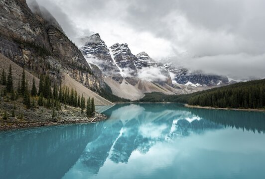 Cloudy mountain peaks, reflection in turquoise glacial lake, Moraine Lake, Valley of the Ten Peaks, Rocky Mountains, Banff National Park, Alberta Province, Canada