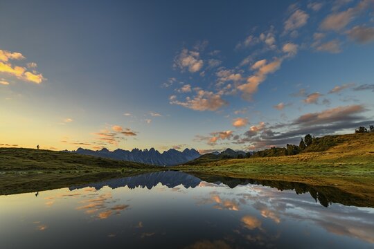 Salfainsee with reflection of the Kalkk&ouml;gel and mountaineers on mountain meadow at sunrise, Sellrain, Innsbruck, Tyrol, Austria