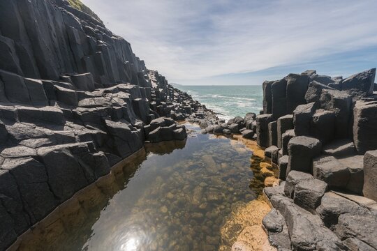 Water gathering between rocks, Roman Bath, Hexagonal basalt column by the Sea, Blackhead, Dunedin, Otago, South Island, New Zealand