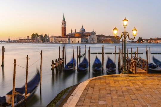 Venetian gondolas at St. Mark's Square in the evening light, blue hour, in the back monastery San Giorgio Maggiore, district San Marco, Venice, region Veneto, Italy