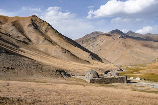 Historic caravanserai Tash Rabat from the 15th century, with yellow hills, Atbashy district in the Naryn region, Kyrgyzstan