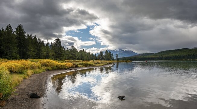 Lake shore of Maligne Lake with autumn vegetation, cloudy sky, Jasper National Park, Rocky Mountains, Alberta, Canada