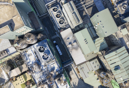 Aerial view of a chemical fiber plant with large ventilation fans, industrial buildings, and complex piping systems in Taiwan.