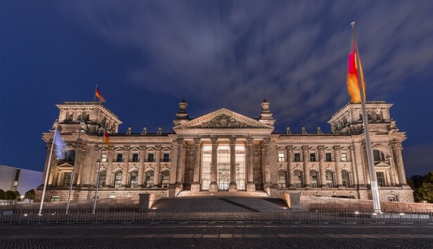 Reichstag with waving German flag, night photograph, government district, Berlin, Germany