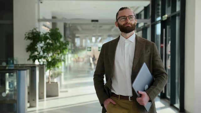 Confident businessman striding with purpose through a modern office building, embodying achievement and a forward-thinking professional journey. Man walking with confidence in a contemporary hall