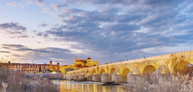 Illuminated Puente Romano, Roman Bridge over Rio Guadalquivir, behind Mezquita, Catedral de C&oacute;rdoba, evening mood, Cordoba, Andalusia, Spain