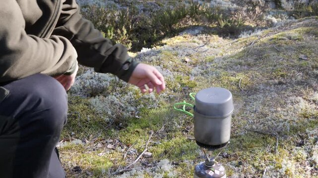 Covering pot on gas stove in forest camping cooking scene