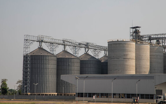 Exterior view of a large-scale animal feed mill plant or grain terminal.Large industrial grain silo complex and food processing factory building.