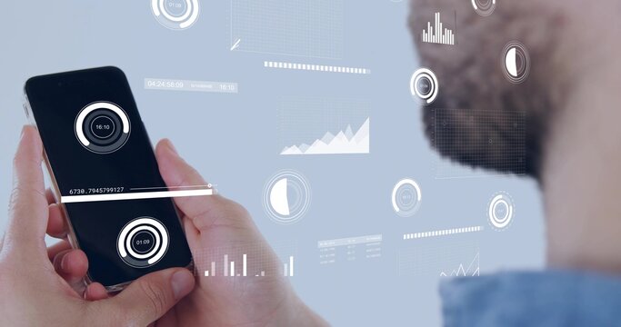 Holding smartphone, man with light blue shirt tapping screen at studio, AR HUD dials, copy space