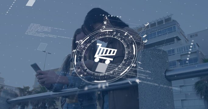 Holding smartphone, two teens leaning on plaza metal railing, wearing jackets, viewing cart HUD