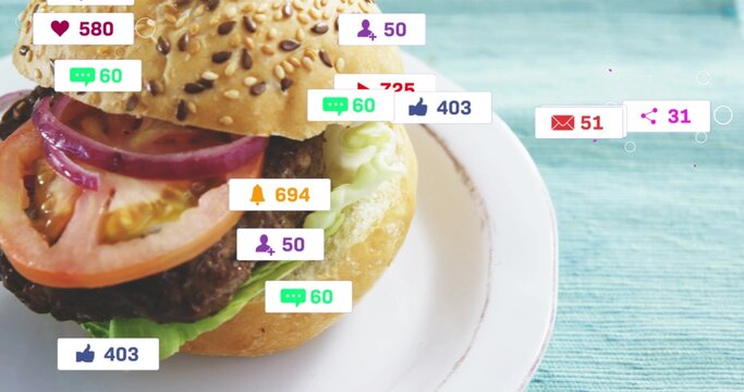 Displaying sesame bun hamburger sitting on white plate over turquoise tabletop, with social badges