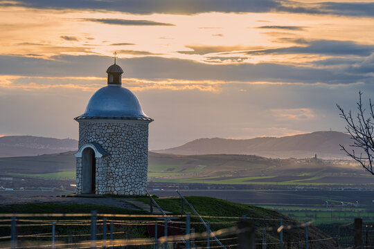 Chapel of St. Cyril and Methodius on Hradistek hill at sunset. Scenic view of South Moravia vineyards and hills in the Czech Republic under a dramatic sky.