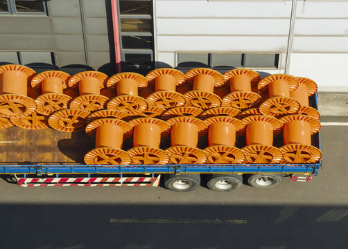 Aerial view of large orange cable reels at a cable factory loaded on a blue flatbed truck in Taiwan.