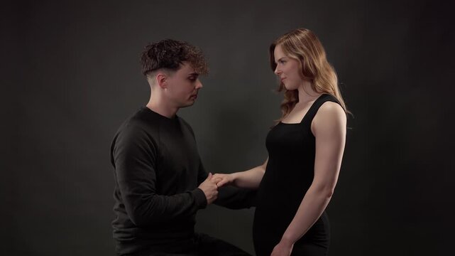 Young man holding his girlfriend's hand while looking at her with love and affection
