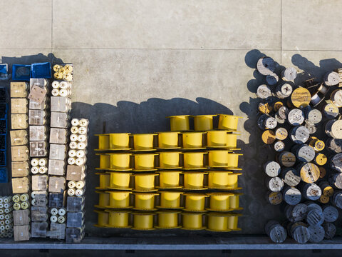 Aerial view of large yellow and wooden cable spools stacked in rows at a cable factory yard Taiwan.