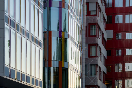 Modern urban corporate offices and buildings facade with glass windows and vivid architecture reflections forming a vertical pattern with abstract geometry