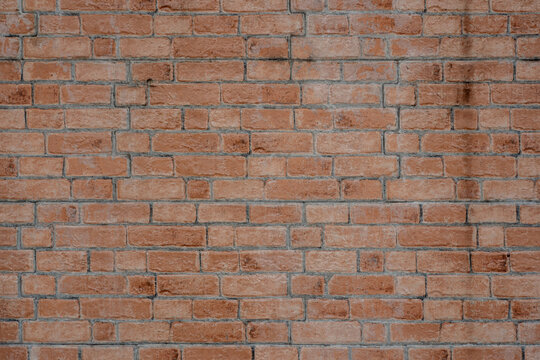 Full frame background texture of a classic red and brown masonry brick wall. High-quality architectural facade texture for backdrops.