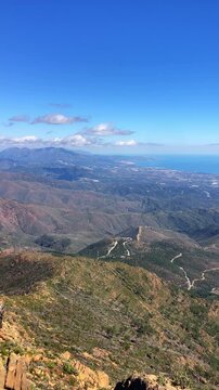 Sweeping mountain panorama revealing the sparkling Mediterranean Sea, Estepona and distant Gibraltar beneath open skies from Sierra Bermeja in Spain.