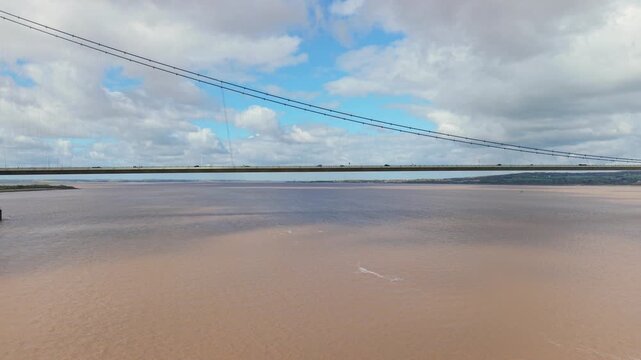 Aerial drone view of the Humber Bridge suspension crossing over the brown tidal estuary