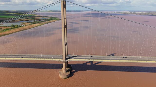 Close up aerial view of the Humber Bridge suspension cables and towers with busy road traffic UK