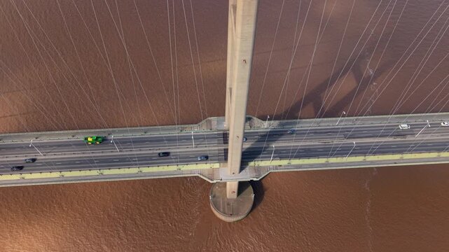 Cinematic close up of the Humber Bridge road deck and suspension system over brown river water