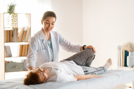 Physiotherapist Assisting Senior Woman in Rehabilitation Exercise at Clinic