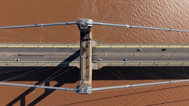 Cinematic close up of the Humber Bridge road deck and suspension system over brown river water