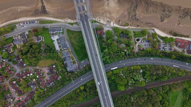 Top down aerial view of Hessle Foreshore and the Humber Bridge tower over the muddy estuary shoreline UK