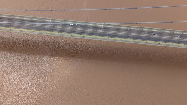 High angle tracking view of vehicles driving over the historic Humber Bridge highway crossing in England