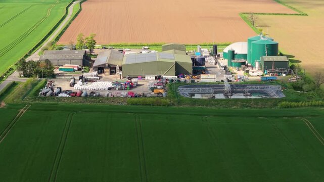 Aerial drone view of a biogas renewable energy facility with anaerobic digesters in rural Lincolnshire fields UK