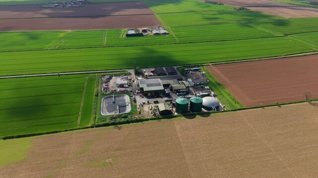 Aerial view of an anaerobic digester facility and biogas domes surrounded by colorful fields in Lincolnshire UK