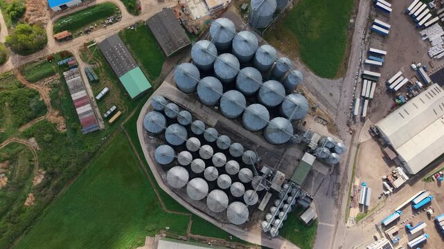 Aerial top down view of galvanized steel grain storage silos on a rural farm in the UK, agricultural infrastructure for cereal crop harvesting.