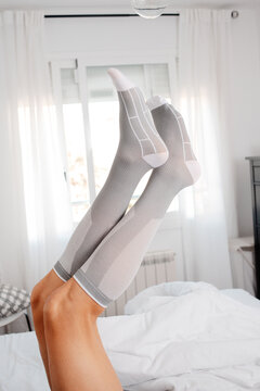 a man keeps both legs raised with compression socks