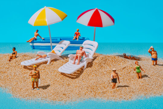 miniature people on a sandy beach scene