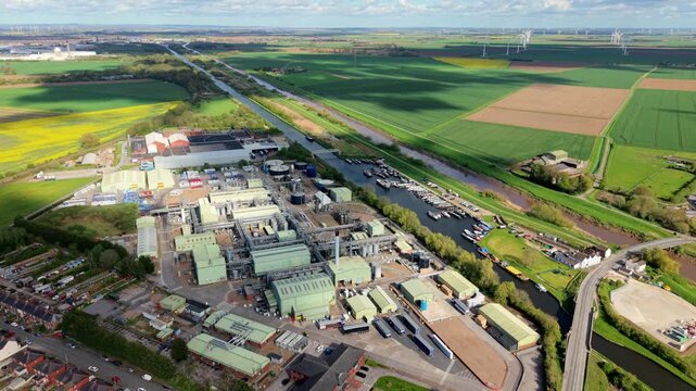 Aerial view of a chemical manufacturing factory by a canal marina with wind turbines in Rawcliffe Bridge UK