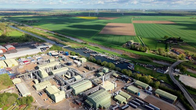 Aerial view of a chemical manufacturing factory by a canal marina with wind turbines in Rawcliffe Bridge UK
