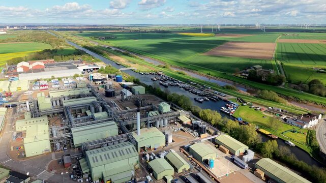 Aerial view of a chemical manufacturing factory by a canal marina with wind turbines in Rawcliffe Bridge UK
