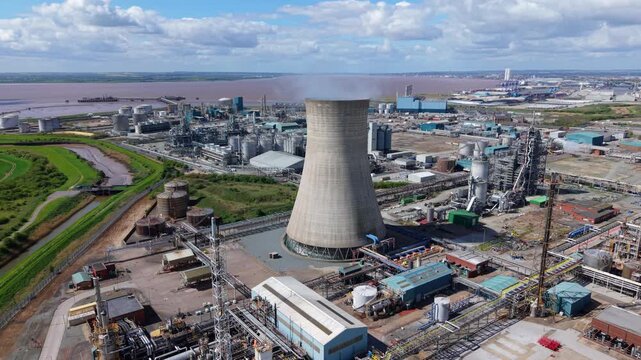 Panning aerial view of Saltend Chemicals Park industrial site and cooling tower on the Humber Estuary UK