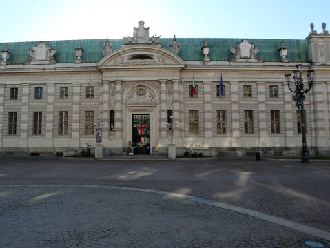 Facciata ottocentesca della Biblioteca Nazionale Universitaria di Torino in Piazza Carlo Alberto con tetto in rame verde e antico lampione in ferro battuto in primo piano, Italia.