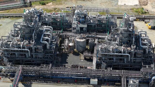 Drone shot of a massive chemical refining facility with large industrial silos and distribution pipelines