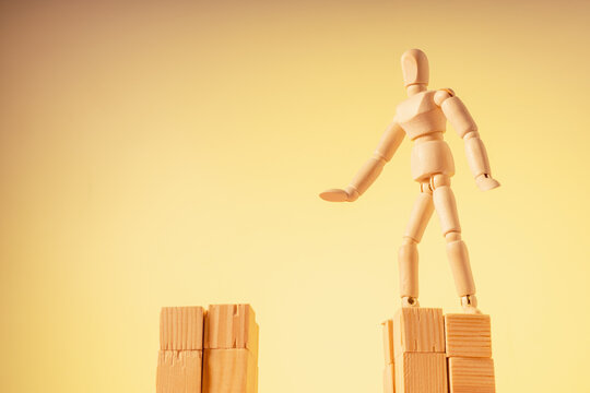 A wooden mannequin stands on a hill and wants to jump to another one