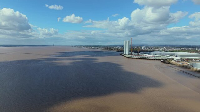 Drone shot of massive renewable energy wind turbine components and assembly quays on the River Humber Estuary near Hull