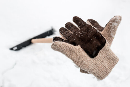 knitted gloves were left after work on the handle of a snow shovel