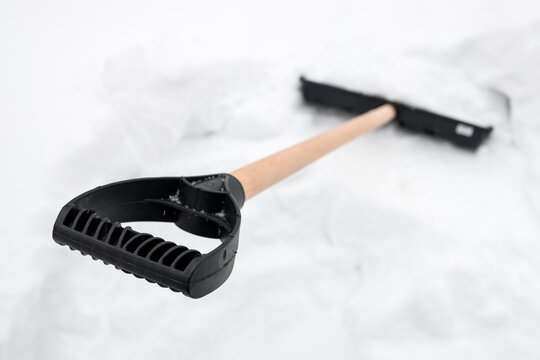 Snow shovel stuck upright in snowdrift, waiting for use