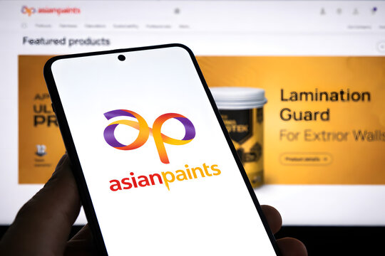 Asian Paints logo displayed on smartphone screen with lamination guard product website in background, Indian paint industry and consumer goods brand concept