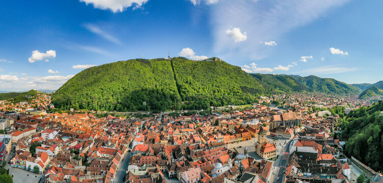 Aerial view of the city of Brasov, with green hill in background, Romania