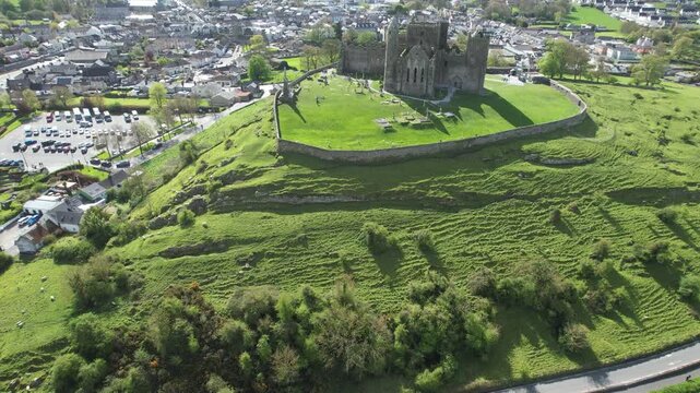 Aerial drone view of the Rock of Cashel, a historic medieval cathedral and fortress rising above the Irish countryside.