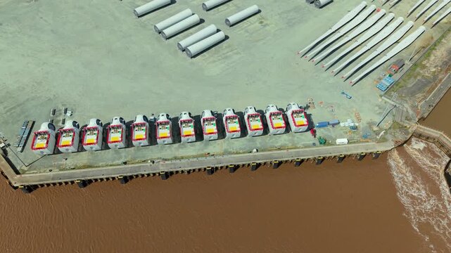 Close up aerial view of wind turbine nacelles lined up on a dock in a construction yard in Hull UK