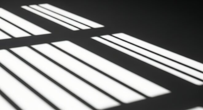 Abstract geometric pattern of parallel light and dark window blind shadows on a dark textured wall