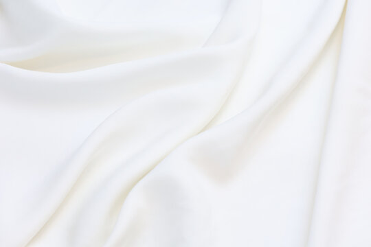 Premium white 100% natural viscose fabric texture with elegant, soft drapes. Lightweight, breathable textile background in vibrant colors. Ideal for fashion design, apparel manufacturing, and sewing.